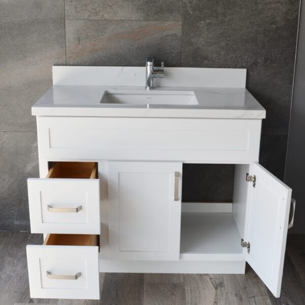 White bathroom vanity with open drawers and cabinet doors.