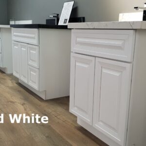 White raised kitchen cabinets on wooden floor.