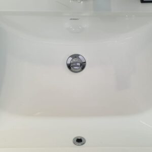 White ceramic kitchen sink with chrome drain.