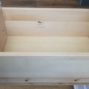 Wooden kitchen drawer with light finish, open and empty.