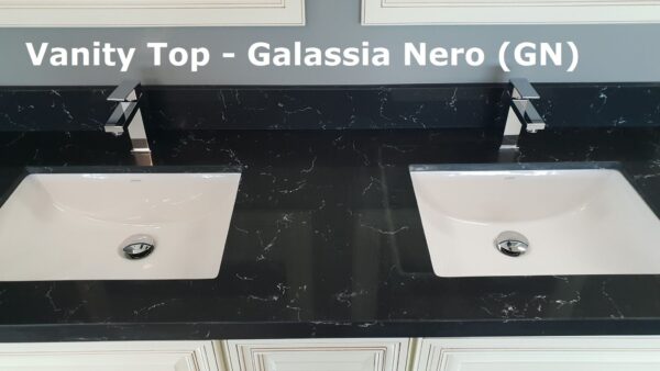 Black vanity top with two sinks and modern faucets.