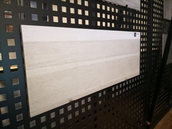 Tile sample displayed on a black perforated board.