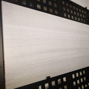 Large rectangular tile displayed on a black grid wall.