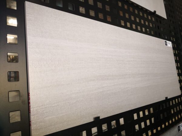 Large rectangular tile displayed on a black grid wall.