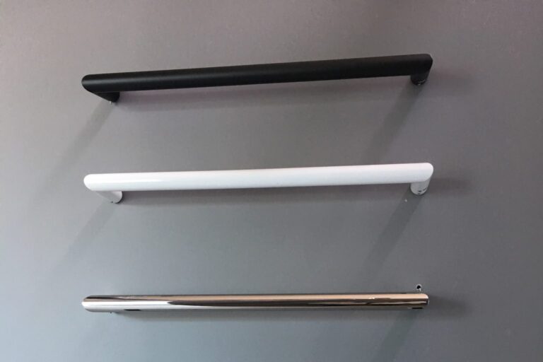 Three modern kitchen cabinet handles in black, white, and chrome.
