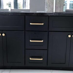 Black marble kitchen cabinet with gold handles in modern setting.