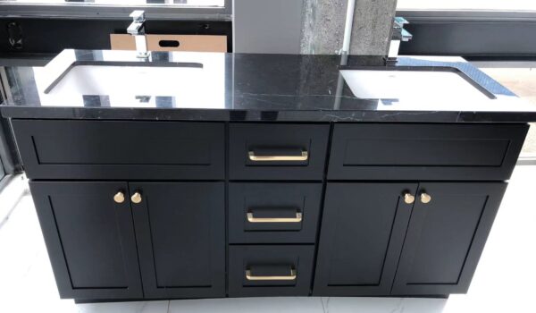 Black marble double sink vanity with gold handles.