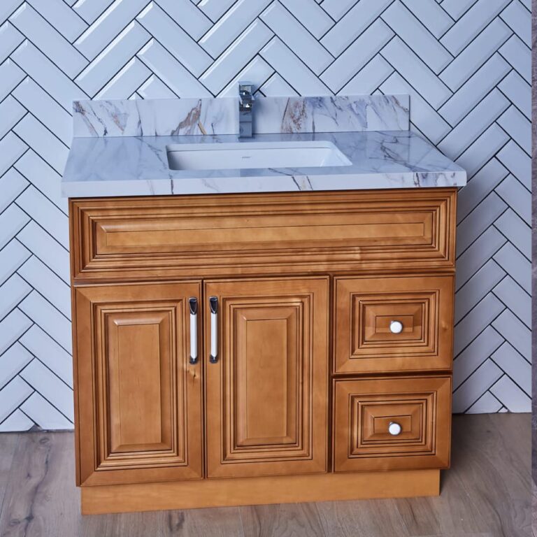 Wooden bathroom vanity with marble countertop and herringbone tile backsplash.