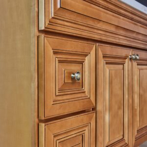 Wooden kitchen cabinet with detailed paneling and metal knobs.