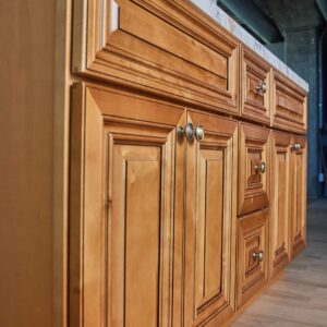 Wooden kitchen cabinets with brass handles in a modern kitchen setting.