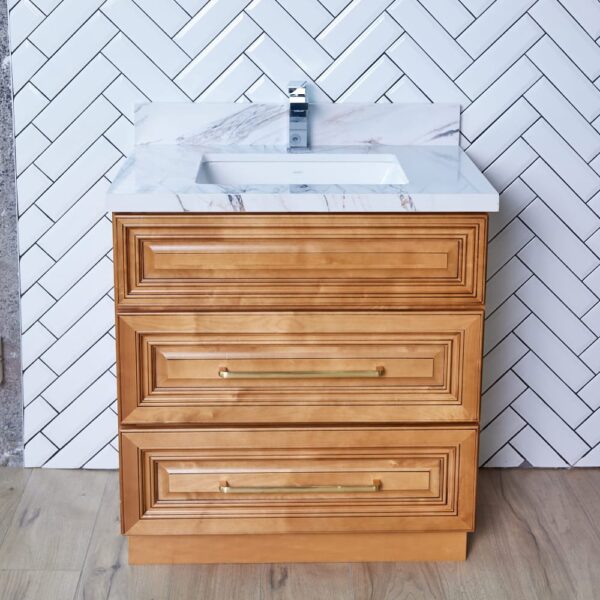 Wooden bathroom vanity with marble countertop and herringbone tile backsplash.