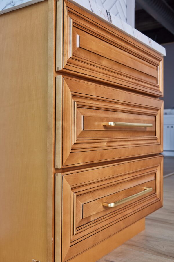 Wooden kitchen cabinet with brass handles.