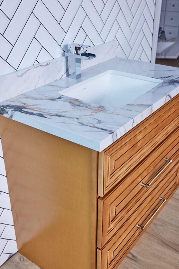 Wooden bathroom vanity with marble countertop and modern faucet.