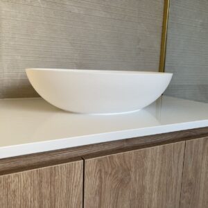 Modern custom bathroom vanity with white basin and wood cabinets.