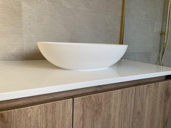 Modern custom bathroom vanity with white basin and wood cabinets.