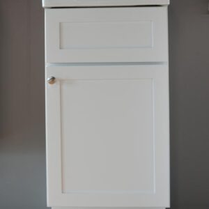 White kitchen cabinet with a single door and silver knob.