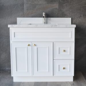 White bathroom vanity with marble countertop and gold knobs.