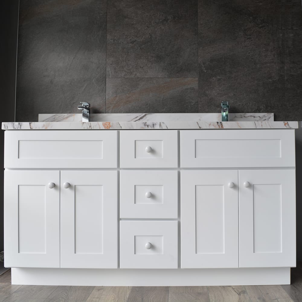 White bathroom vanity with marble countertop and dual faucets.