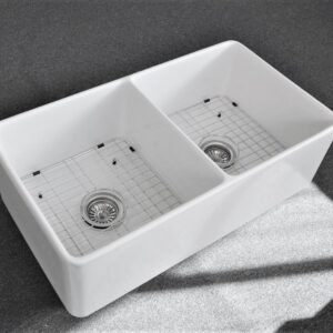 Double bowl white kitchen sink on gray countertop.