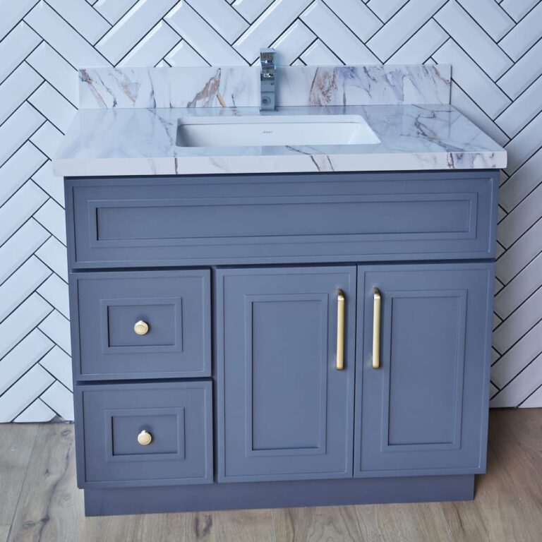 Blue bathroom vanity with marble countertop and gold handles.