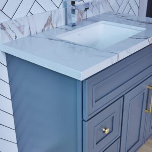 Blue bathroom vanity with marble countertop and modern faucet.