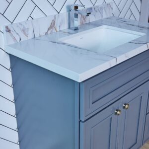Blue bathroom vanity with marble countertop and modern faucet.