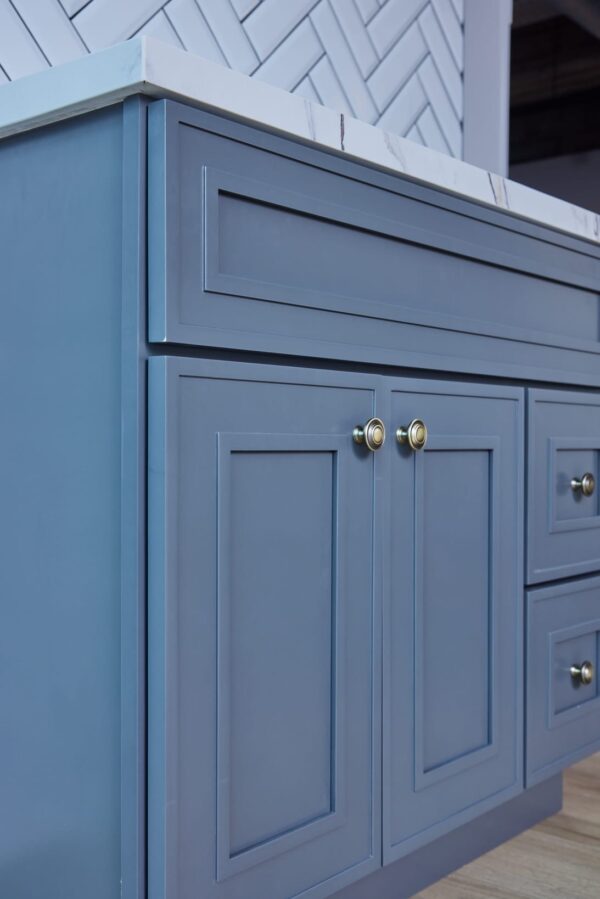 Blue kitchen cabinet with brass knobs.