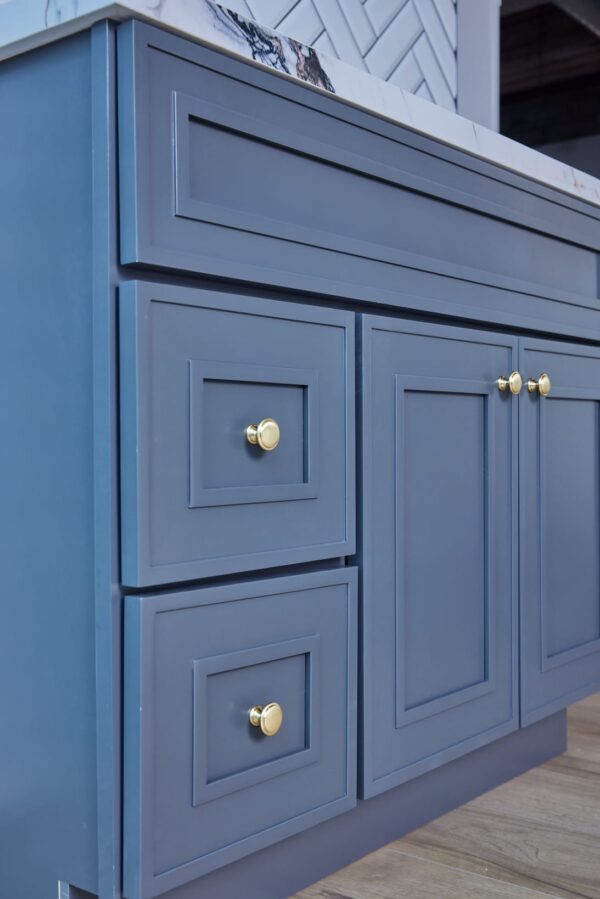 Blue kitchen cabinets with gold knobs.