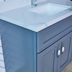 Blue bathroom vanity with marble countertop and silver handles.
