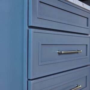 Blue kitchen cabinet drawers with silver handles.