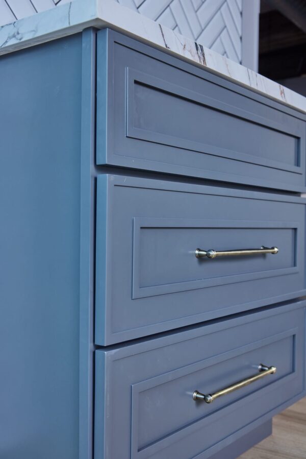 Blue kitchen cabinet drawers with silver handles.
