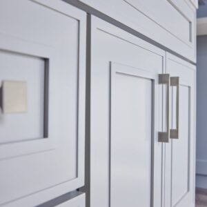 White kitchen cabinets with modern square handles.