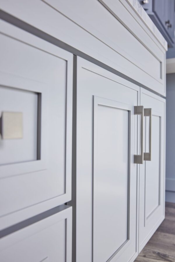 White kitchen cabinets with modern square handles.