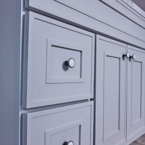 White kitchen cabinet with silver knobs.