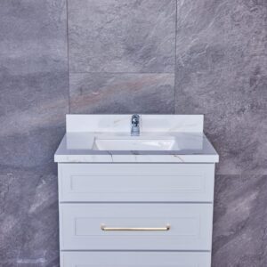 Modern bathroom vanity with marble countertop and gray tile background.