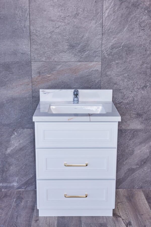 White bathroom vanity with marble countertop against gray tiled wall.