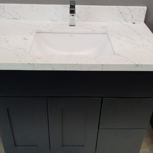 Modern bathroom vanity with white marble countertop and sleek black cabinet.