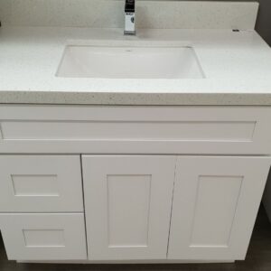White bathroom vanity with sink and faucet.