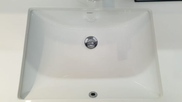 White ceramic kitchen sink with chrome drain.