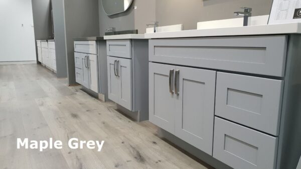 Maple Grey kitchen cabinets in a showroom with light wood flooring.