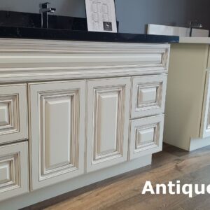 Antique White kitchen cabinets with intricate panel design and dark countertop.
