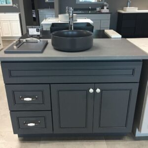 Dark gray kitchen cabinet with black sink and modern faucet.