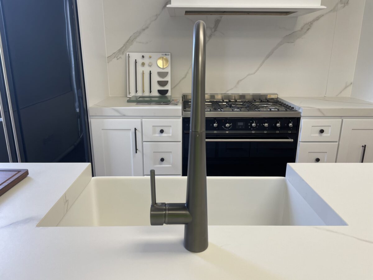 Modern kitchen with sleek faucet and marble backsplash.