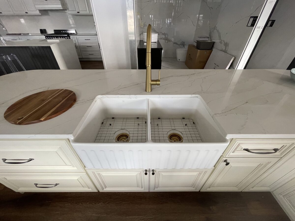 Modern kitchen with marble countertop and double farmhouse sink.