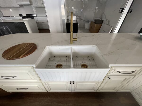 Modern kitchen with marble countertop and double farmhouse sink.
