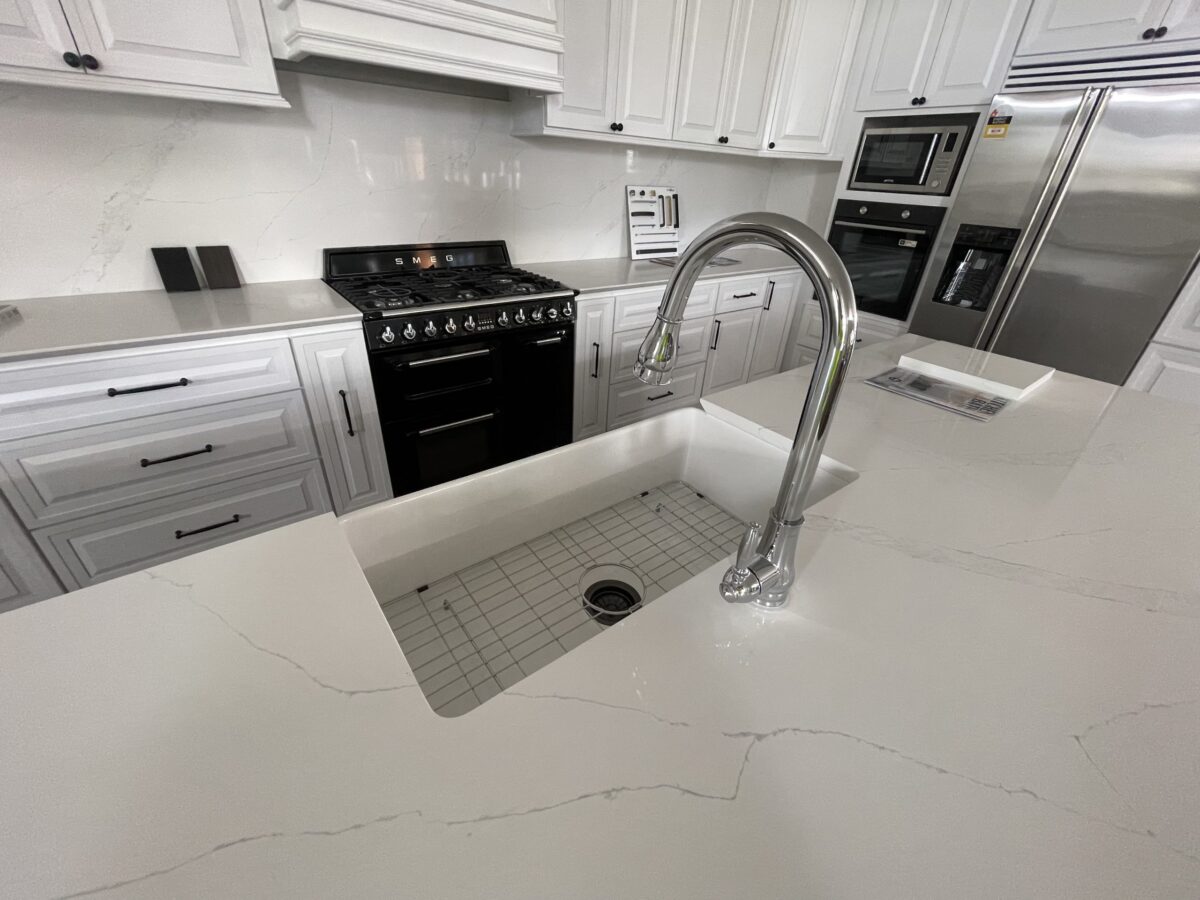 Modern kitchen with white cabinets and stainless steel appliances.
