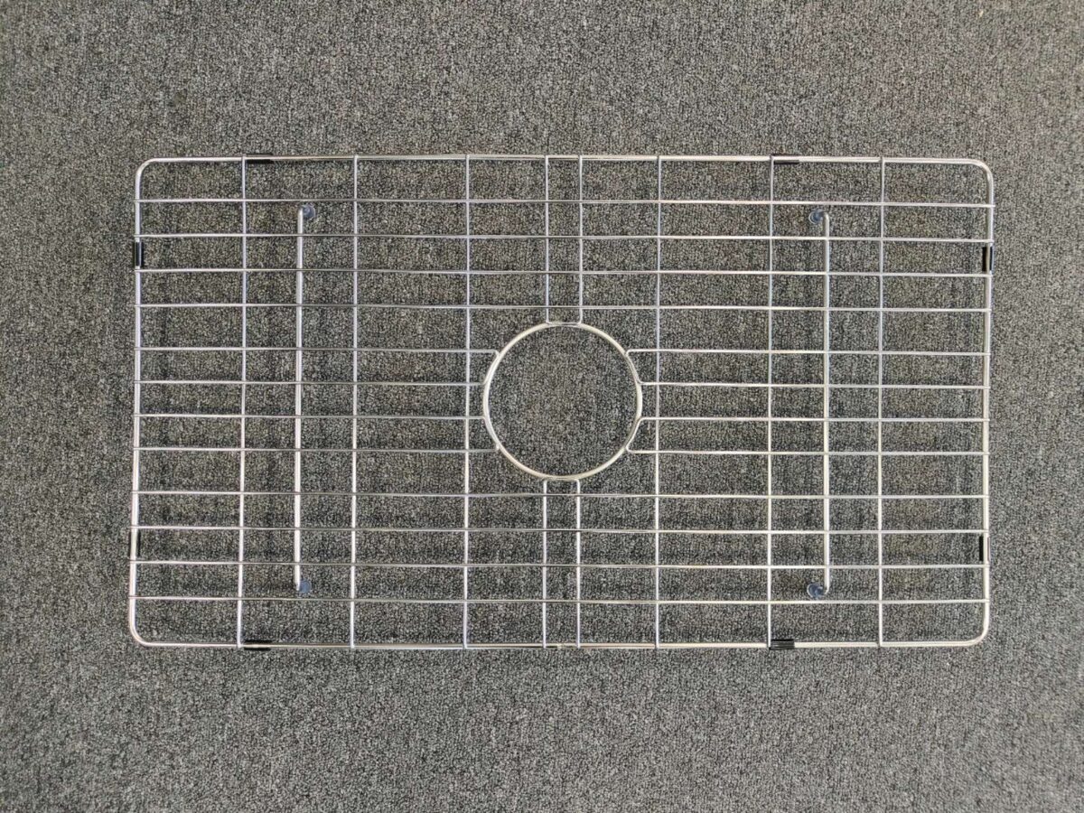 Metal sink protector on a gray surface.