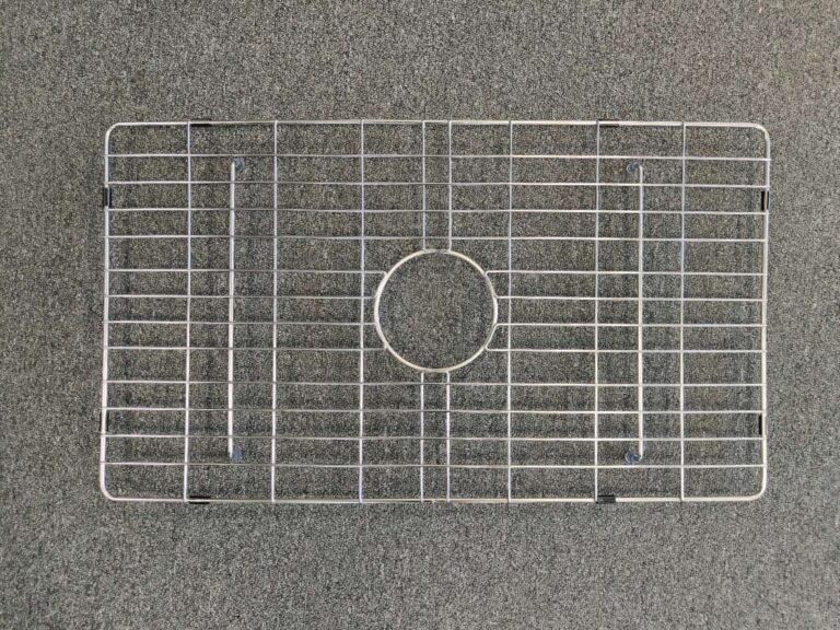 Metal sink protector on a gray surface.