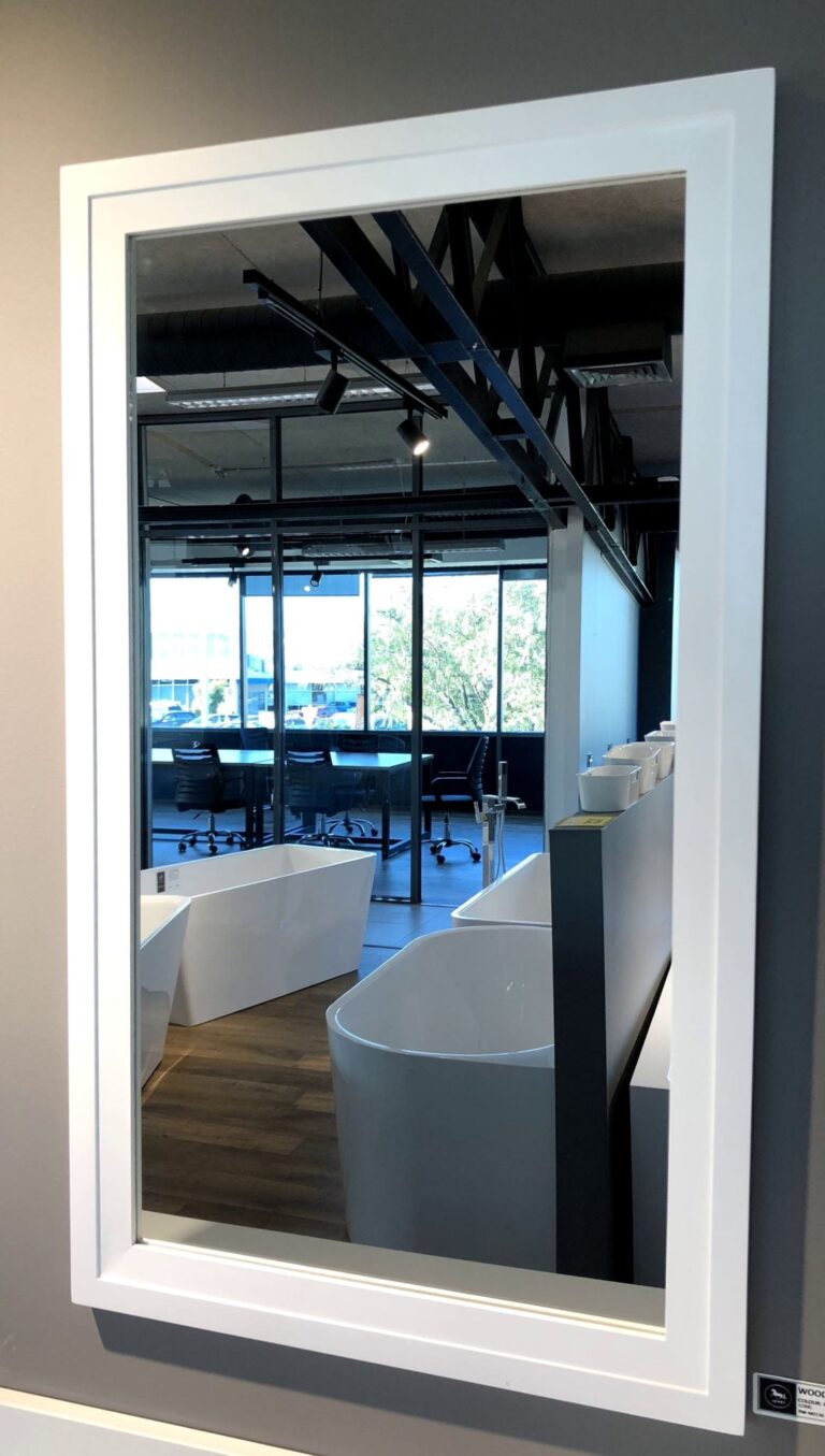 Modern bathroom showroom with large mirror and bathtubs.