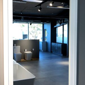 Showroom with bathroom fixtures and large wall mirror.